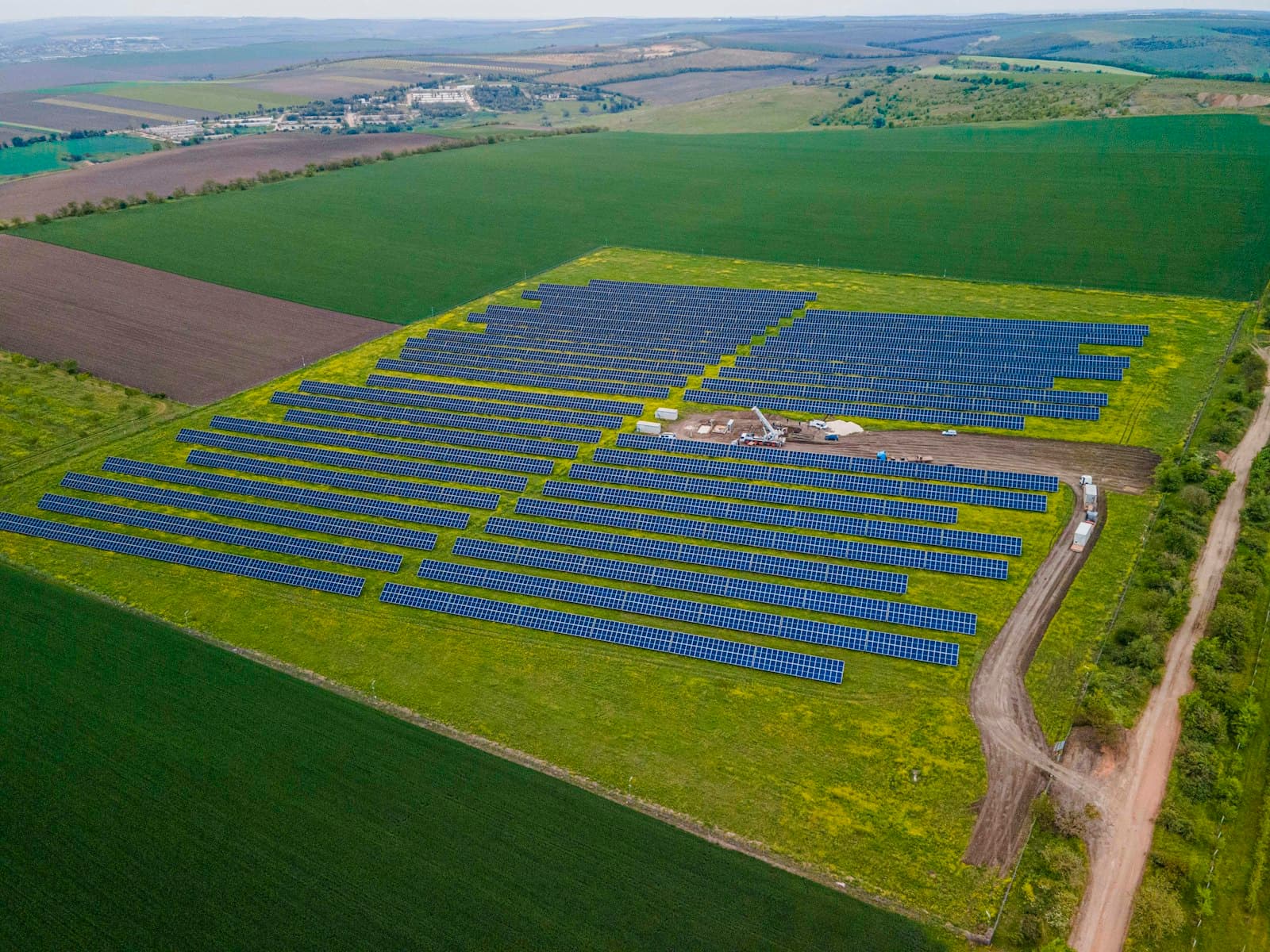 Aerial view of a solar farm among green fields
